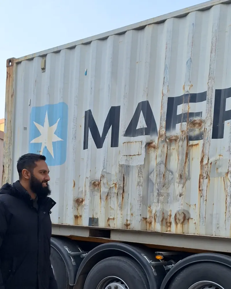 Katfusion team member beside a shipping container on a truck